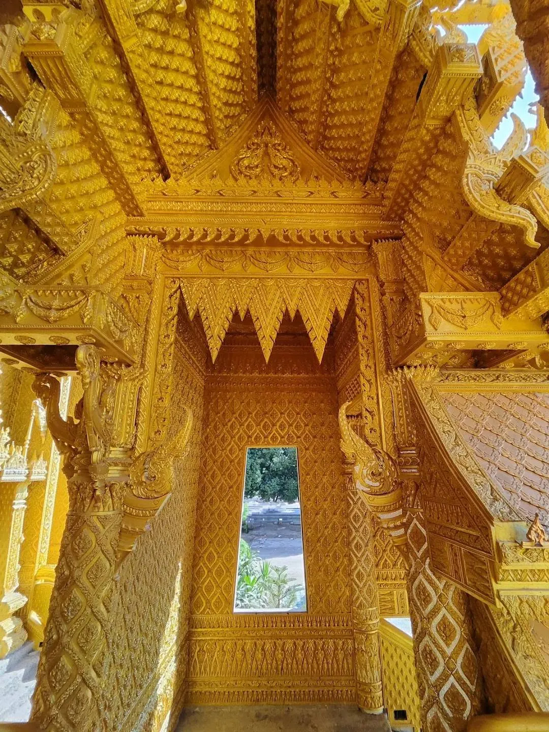 Carved golden corridor and window at Wat Chan Tawan Tok