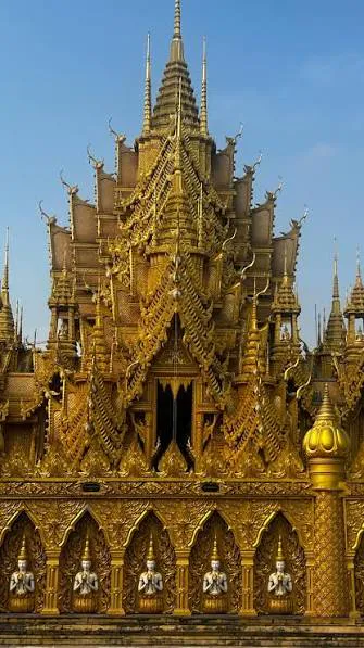 Seated Buddha figures in golden niches on the viharn façade