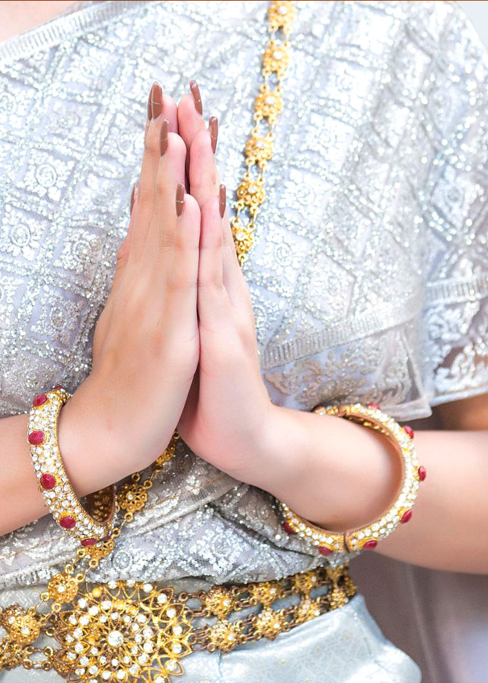 A traditional Thai wai greeting in ceremonial dress