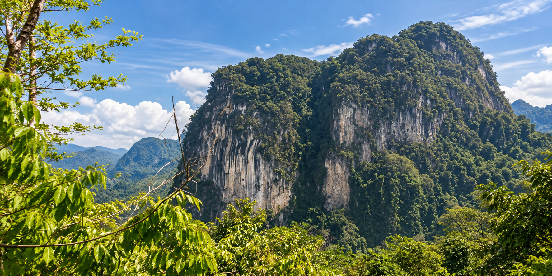 Forest-covered limestone mountains rising above tropical forest at Kaeng Krung National Park