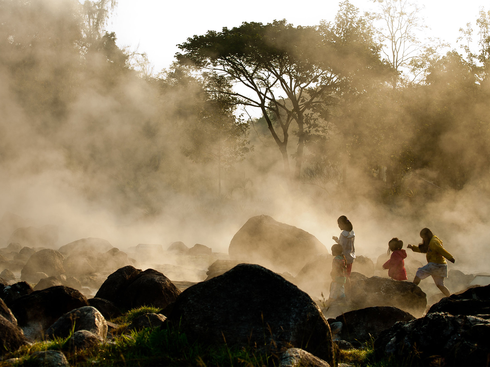Visitors walking through golden steam at Chae Son National Park hot springs in Lampang