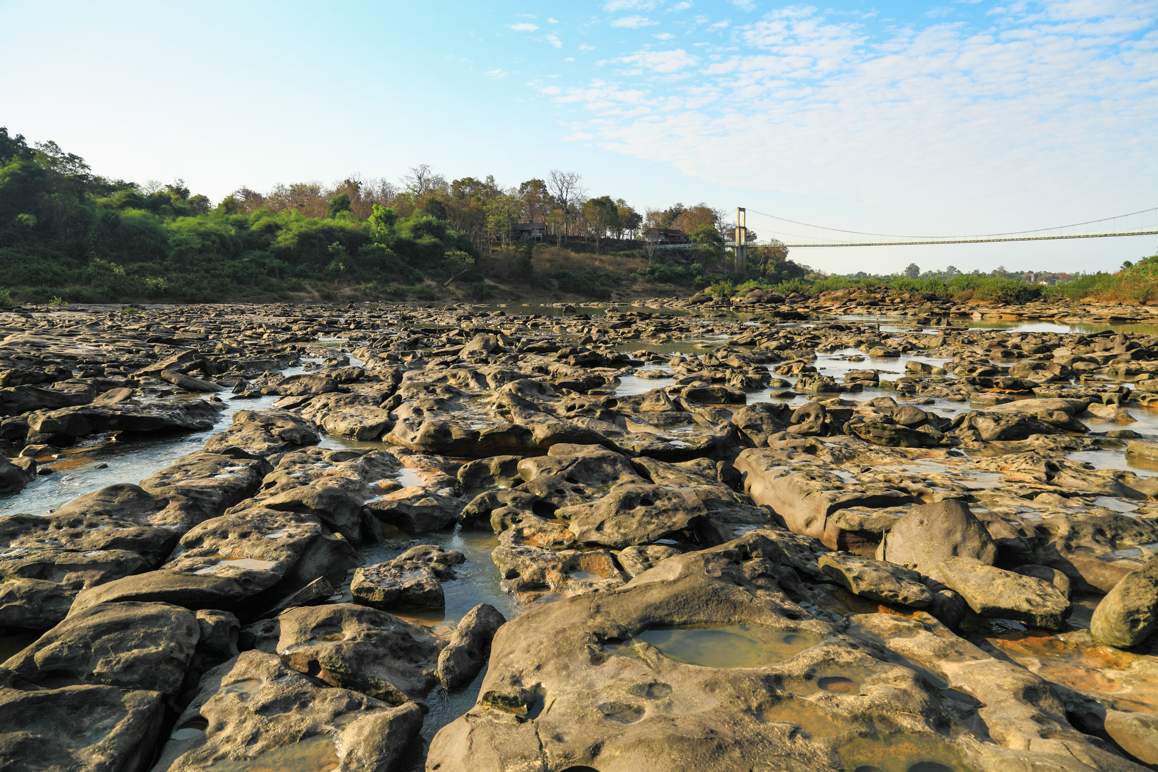 Exposed Mun River sandstone and a suspension bridge at Kaeng Tana National Park