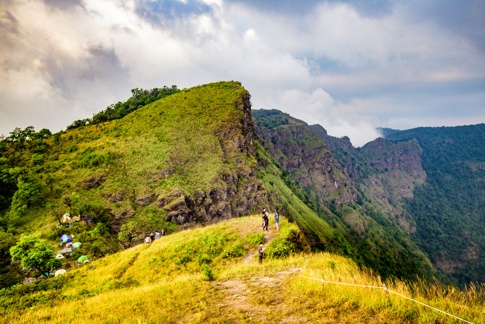 Hikers on the grassy ridge of San Nok Wua, the highest peak in Khao Laem National Park