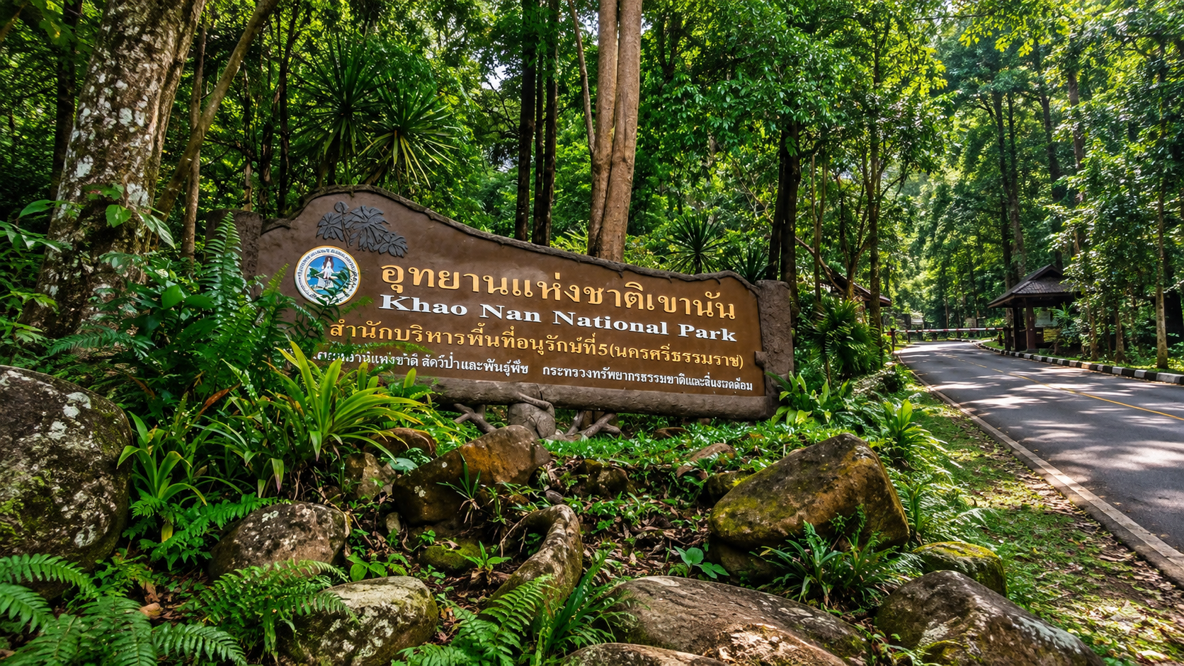 Entrance sign to Khao Nan National Park among rainforest beside the park road, Nakhon Si Thammarat