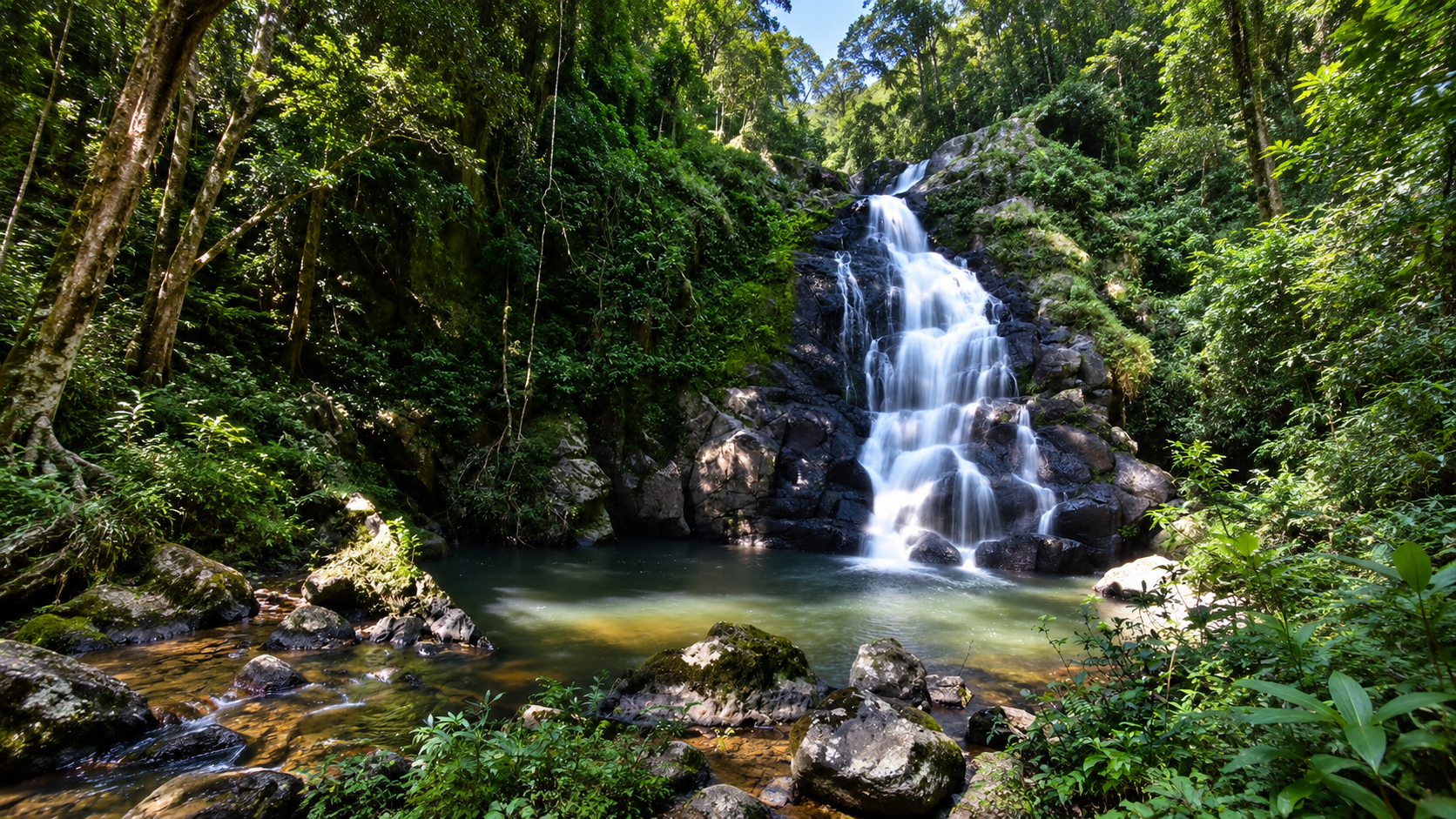 A three-tier waterfall cascading into a forest pool at Khun Nan National Park, Nan