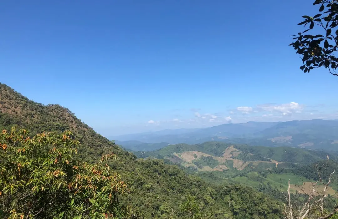 Forested ridges and cultivated mountain valleys under a clear blue sky at Khun Phawo National Park, Mae Ramat and Mae Sot, Tak