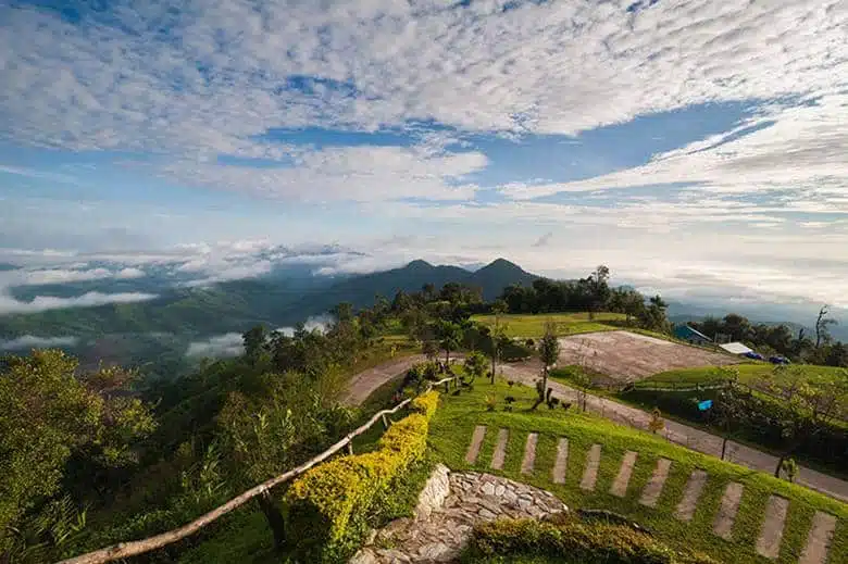 Highland viewpoint, winding road and mist-filled valleys at Doi Mae Chok, Khun Sathan National Park, Nan