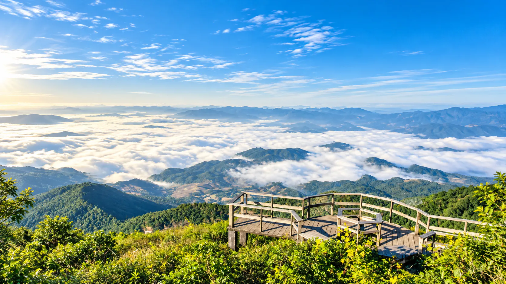 A wooden viewpoint on a forested ridge above a sea of clouds and layered mountains at sunrise, Lam Nam Nan National Park
