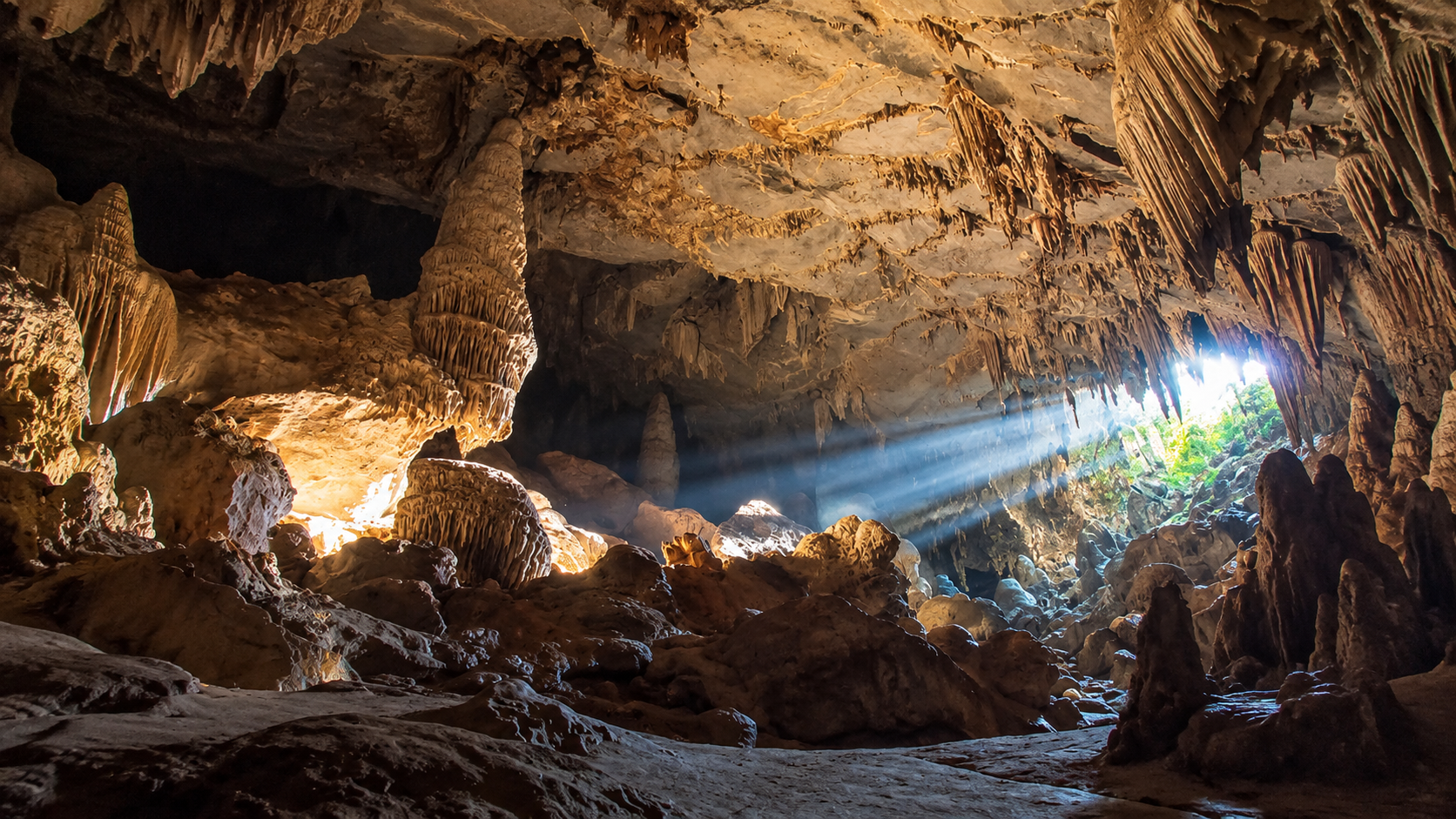 Shafts of daylight falling through limestone columns inside Mae U-Su Cave at Mae Moei National Park, Tak