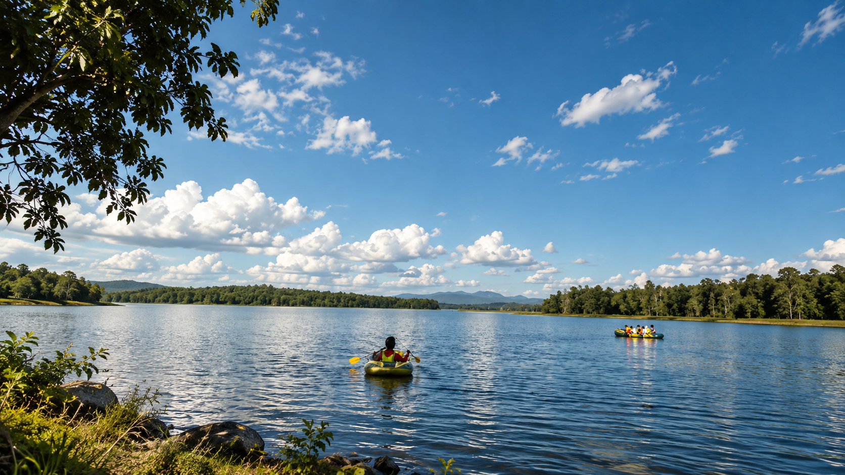 Kayakers on Mae Puem Reservoir, with forested hills under a bright northern sky