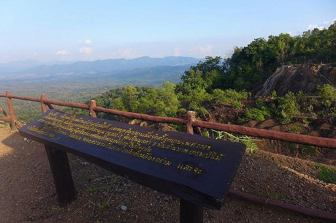 A wooden information board looking across forested ridges at a Mae Yom viewpoint