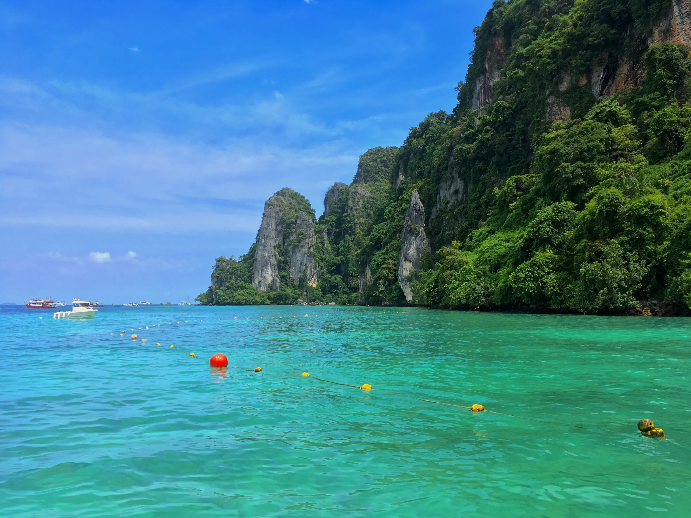Vertical limestone cliffs and clear turquoise Andaman water in Mu Ko Phetra National Park