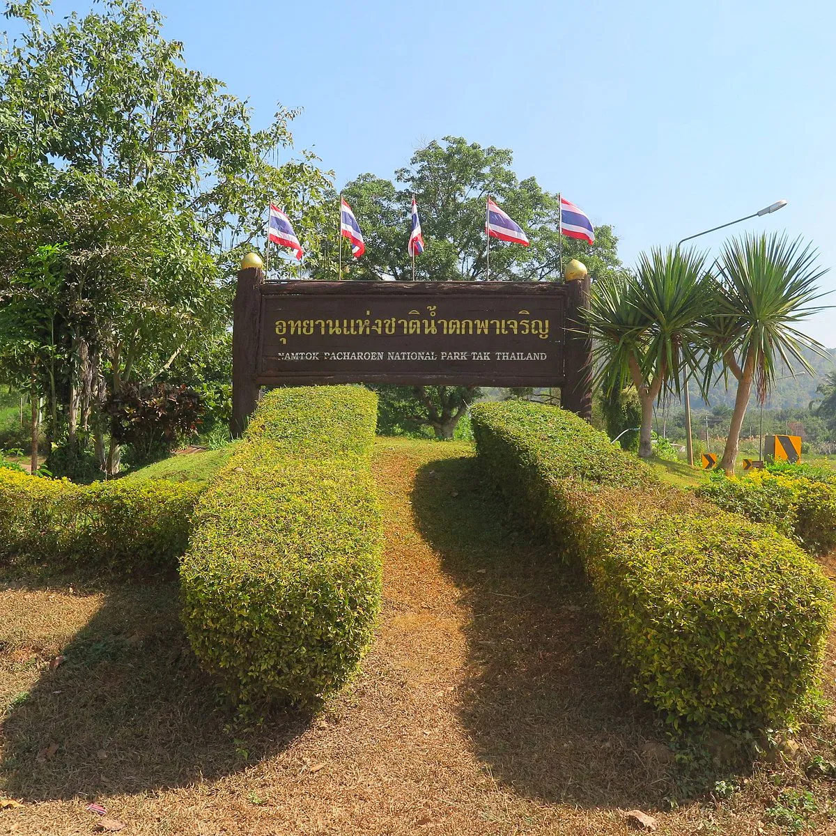 Wide limestone staircase of Pha Charoen Waterfall cascading through tropical forest