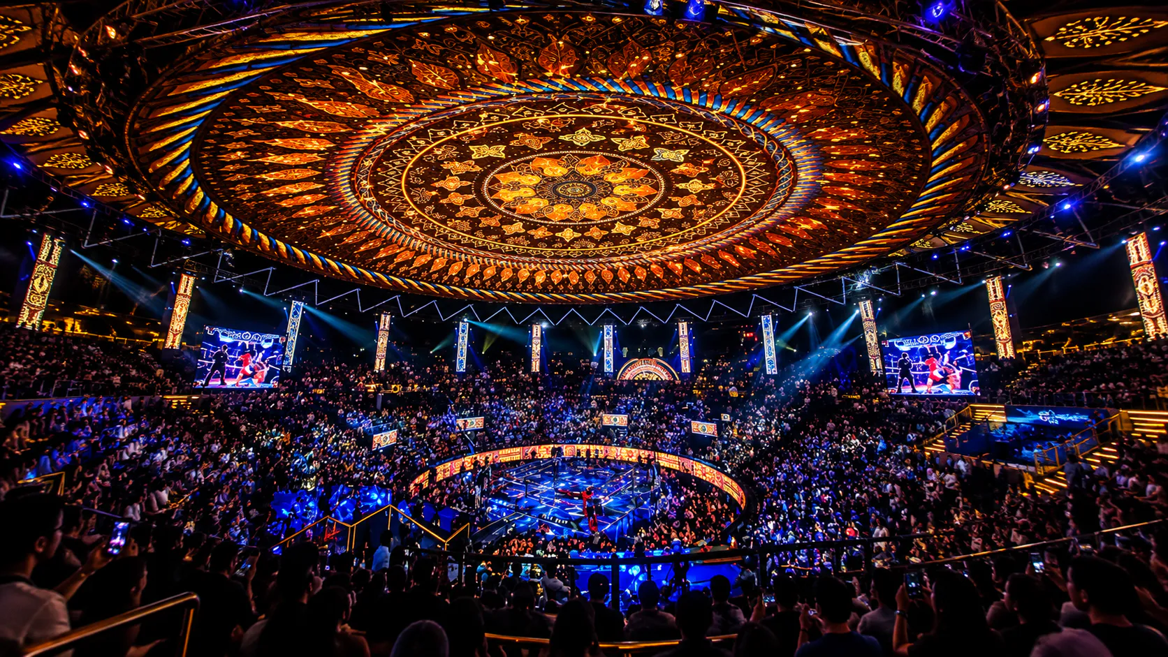 Packed Rajadamnern Stadium under its ornate golden dome during a live Muay Thai fight