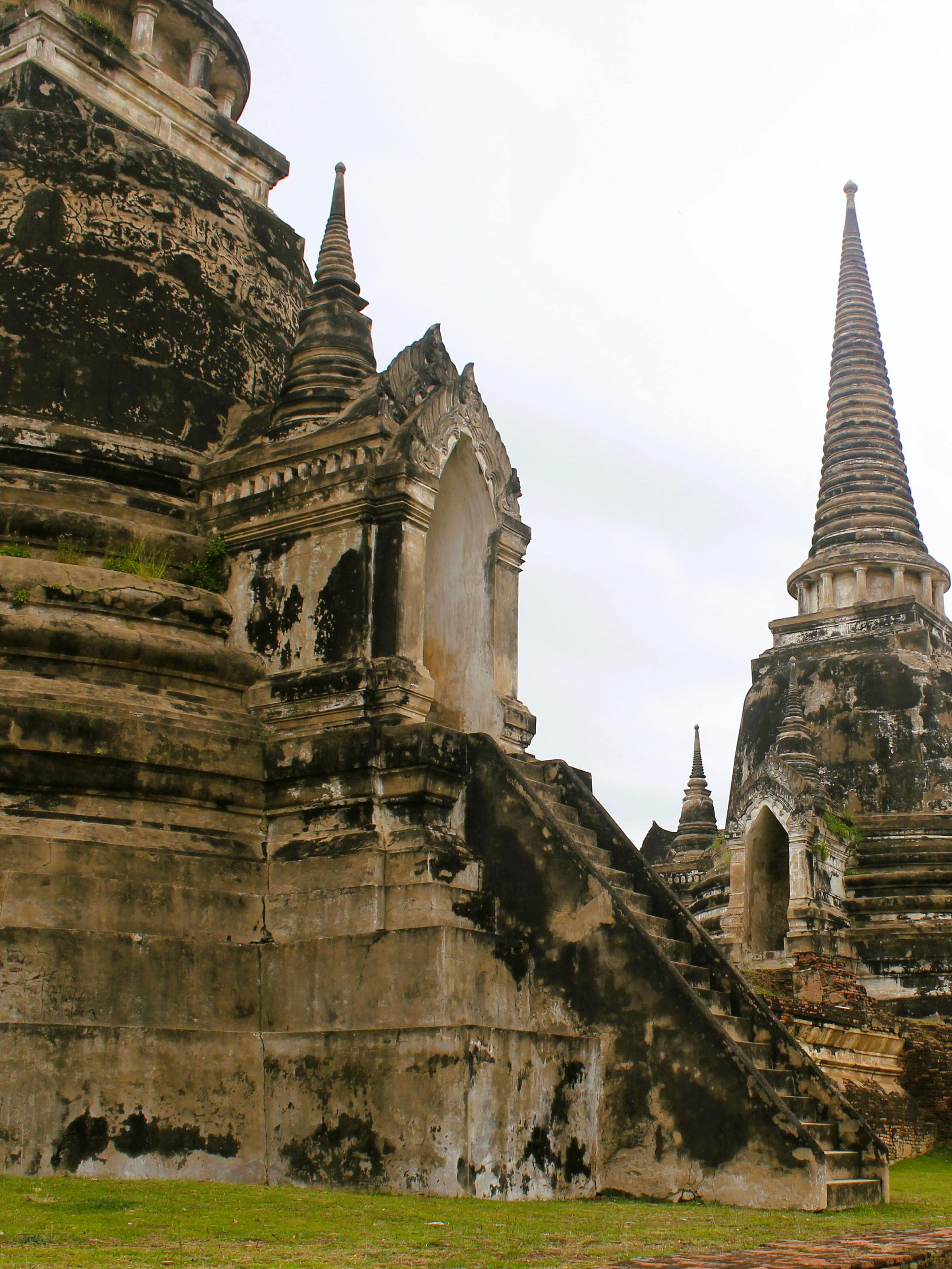 Ancient stone chedis rising from the grass at Ayutthaya Historical Park