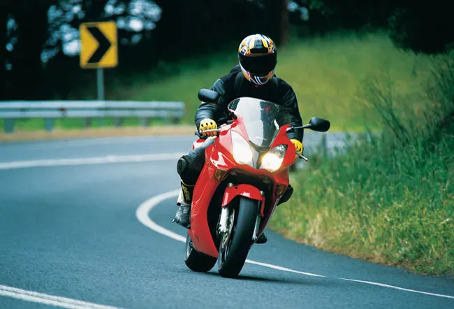 Motorcyclist on a winding road in full protective gear