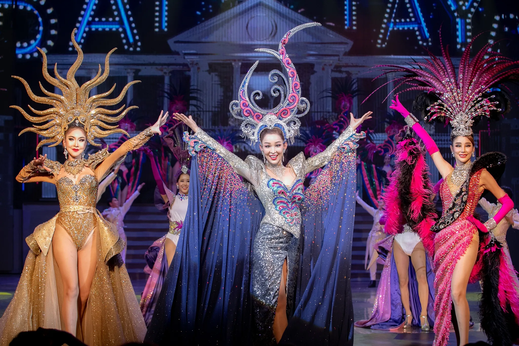 Performers in jewelled headdresses and sequinned costumes on a Pattaya cabaret stage
