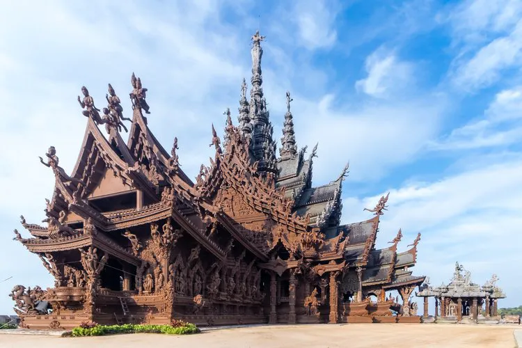The Sanctuary of Truth in Pattaya, an immense carved wooden sanctuary with layered gables and spires under a bright sky