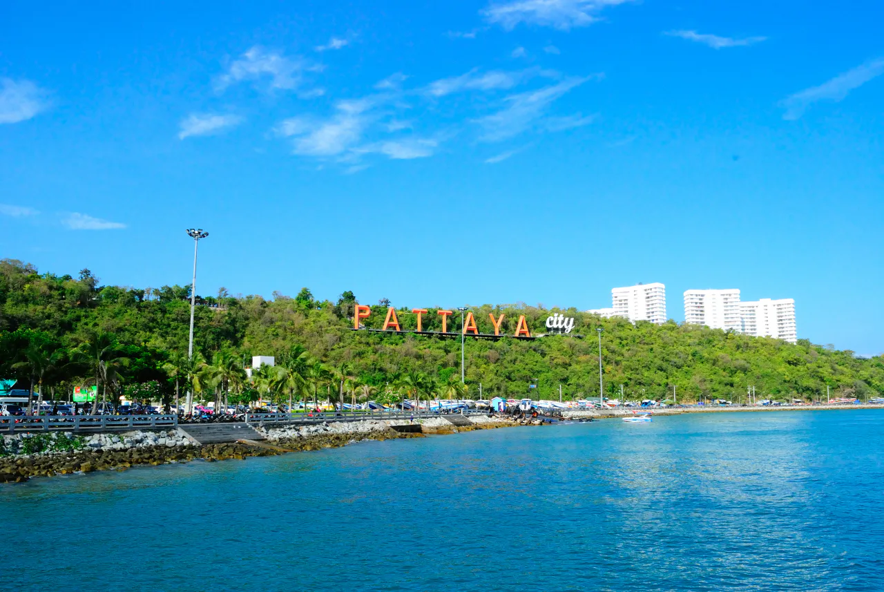 The Pattaya City sign on a green headland above the Gulf of Thailand